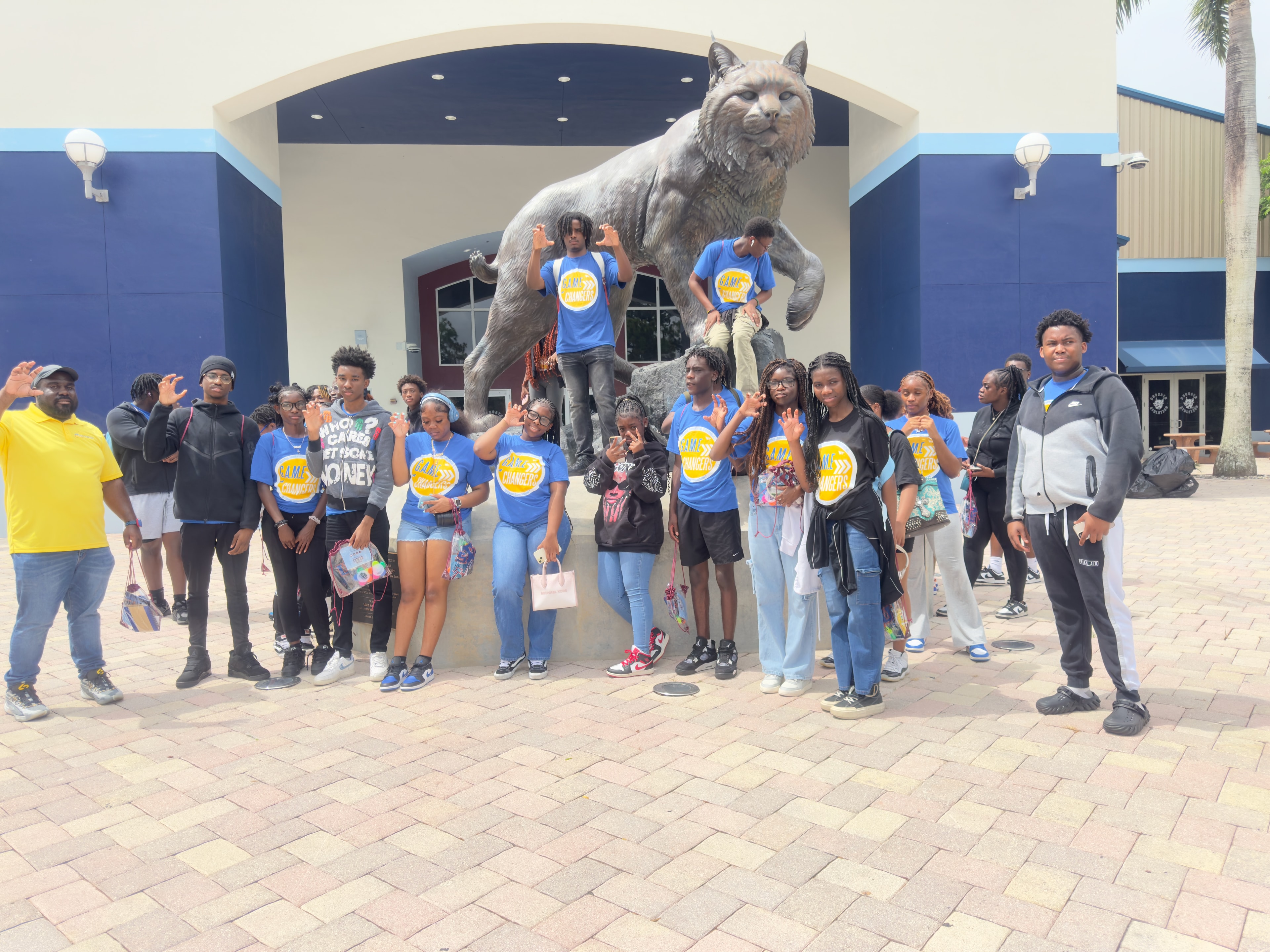 Students posing by wildcat statue on campus